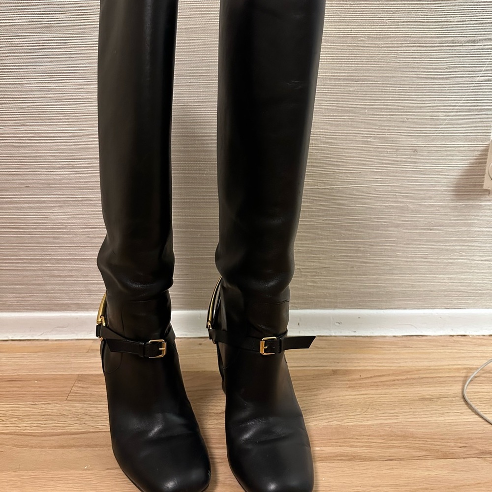 Gucci knee high black leather riding boot with gold buckle.